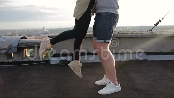 日落时分一个男人在屋顶上把他的女朋友翻了个身慢动作视频的预览图