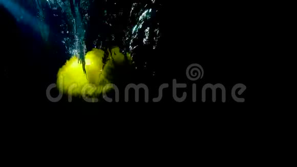 黄色柠檬在黑色背景下倒在水里慢动作视频视频的预览图