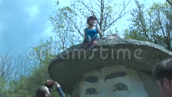 游客们被拍到戴着帽子的大头纪念碑一个戴着头盔的年轻女孩坐在纪念碑帽子上A视频的预览图