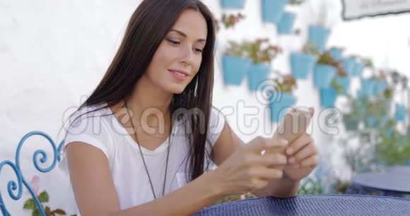 户外智能手机桌上的漂亮女孩视频的预览图