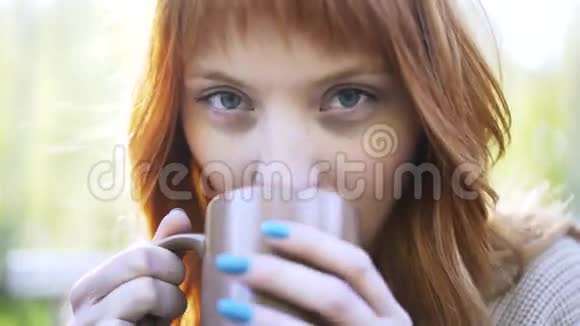 一个红头发的女人在公园喝热饮料视频的预览图