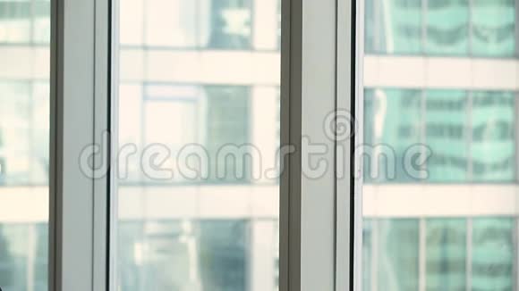 幸福微笑的女商人站在办公室的大窗户旁沉思着城市风景视频的预览图