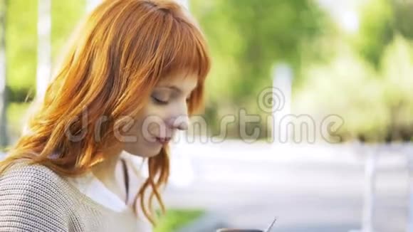 一个红头发的女人在外面喝茶视频的预览图