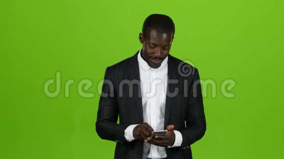 非洲人拿着电话翻着信息绿色屏幕视频的预览图