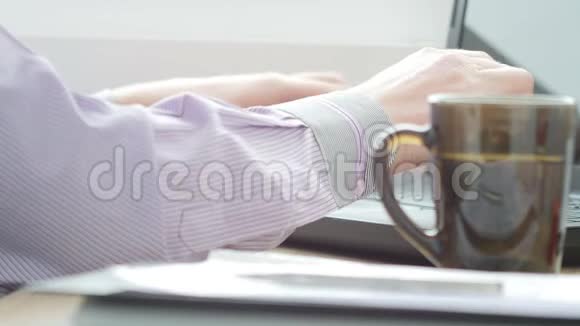 商人在笔记本电脑上喝茶蚂蚁打字超高清视频视频的预览图
