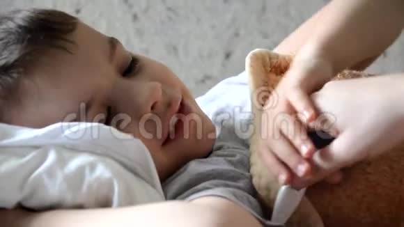 婴儿药和生病的孩子男孩躺在沙发上发烧休息在家里妈妈给她的儿子吃药视频的预览图