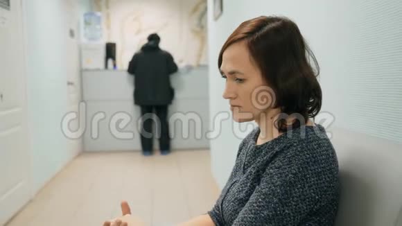 诊所里有个女人坐着等轮到她看医生视频的预览图