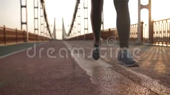 日落时分在桥上奔跑的特写女性双脚视频的预览图