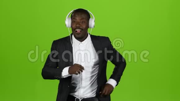 非裔美国人跳动拉丁语在耳机里听音乐绿色屏幕视频的预览图