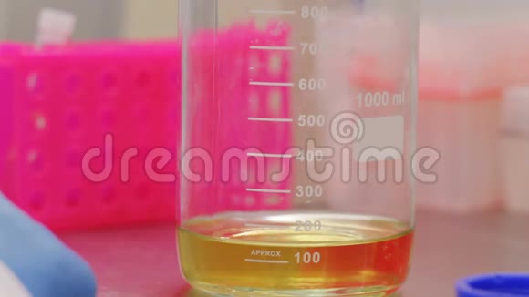 生物技术专家从玻璃瓶中取出一个黄色液体的样品进行测试视频的预览图