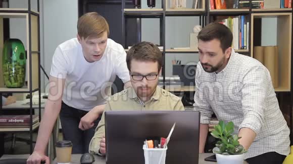 三个严肃的程序员在笔记本电脑前头脑风暴视频的预览图