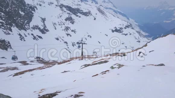 缆车在滑雪场行驶白雪覆盖的山脉冬季的风景视频的预览图