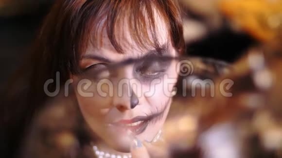 万圣节派对特写化妆艺术家在万圣节派对上给一个黑发女人的脸上画了一个可怕的妆容视频的预览图