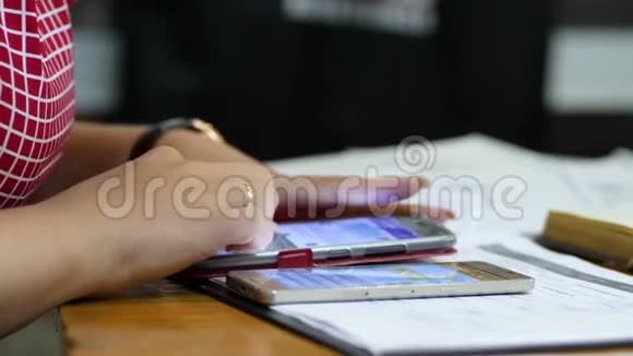 女性手特写在智能手机上写短信女性坐在办公桌前视频的预览图