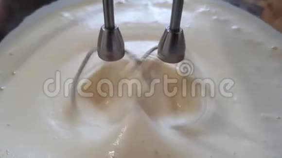 搅拌机迅速转动一个盘子上面有鸡蛋和牛奶的液体面糊奶油或煎饼视频的预览图