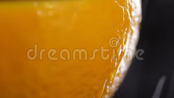 橙色外壳靠近黑色背景带有水滴的橙色宏观射击柑橘树上的水滴视频的预览图