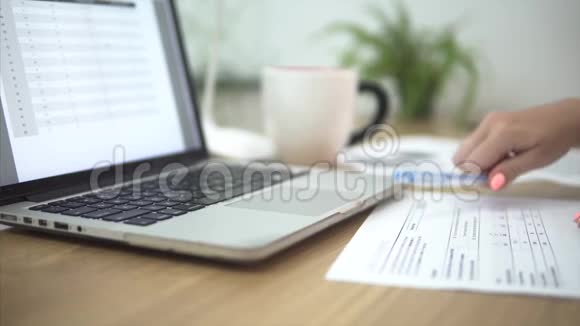 年轻的女商人在办公室工作场所使用笔记本电脑检查纸文件周围是纸视频的预览图