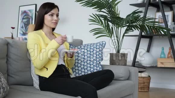 女人一边喝咖啡一边坐在沙发上视频的预览图