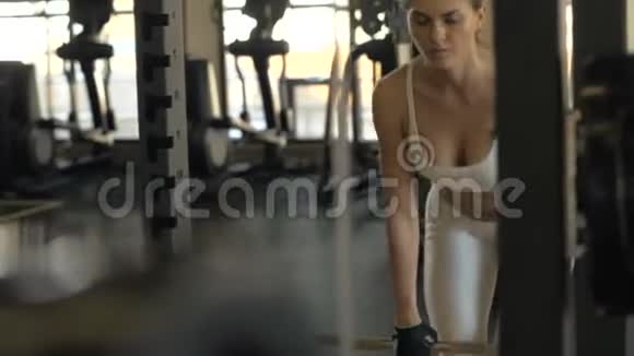 健身俱乐部运动女性用杠铃前镜训练臀部肌肉视频的预览图