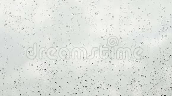 灰色天空上玻璃窗上的雨滴视频的预览图