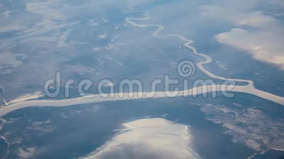 从飞机的窗户上可以看到冰封河流的冬季景观视频的预览图