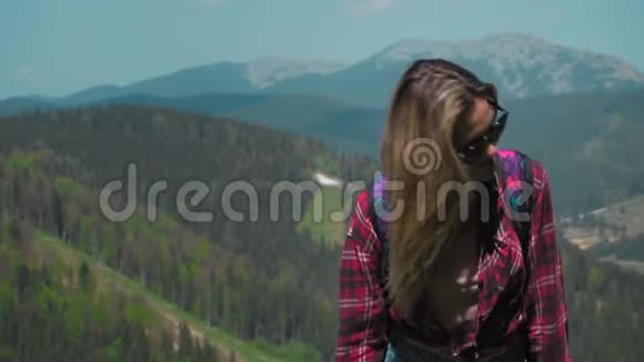 一个年轻的高加索女人带着背包和太阳镜上山个人成长的概念克服视频的预览图