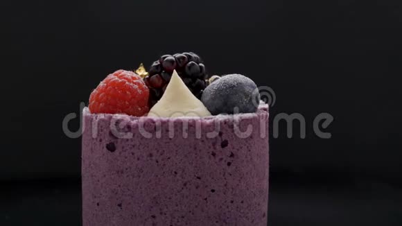 黑色背景下带有黑莓蓝莓慕斯的美味蛋糕视频的预览图