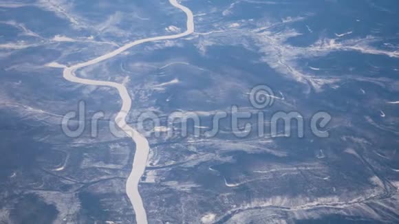 从飞机的窗户看冬天的陆地和冰封的河流视频的预览图