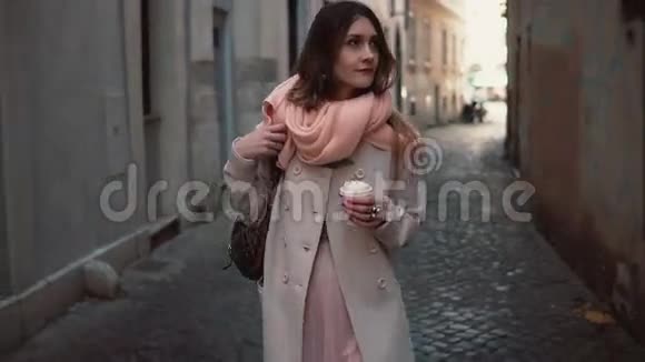 在市中心散步的年轻时尚女性的肖像快乐女孩探索古老的街道喝咖啡视频的预览图