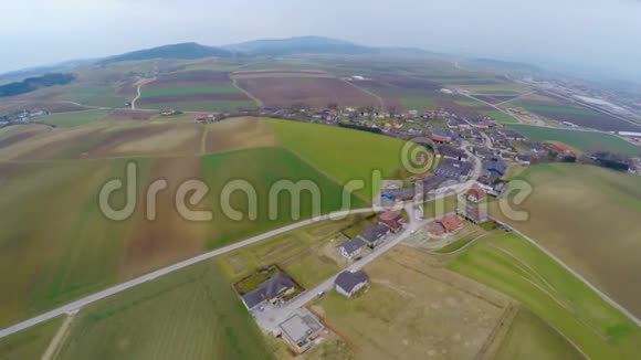 空中拍摄的绿色牧场耕地农场和农舍农业视频的预览图