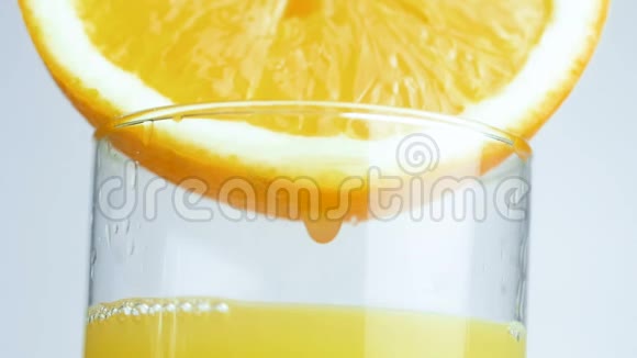 巨幅特写镜头液滴从橙汁一侧缓慢滴入视频的预览图