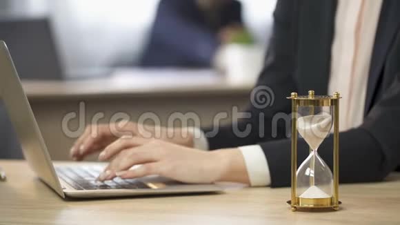 女士在办公室工作笔记本电脑沙漏测量时间工作效率视频的预览图