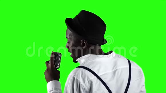 非裔美国人从背后看麦克风在录音室专业唱歌绿色屏幕视频的预览图