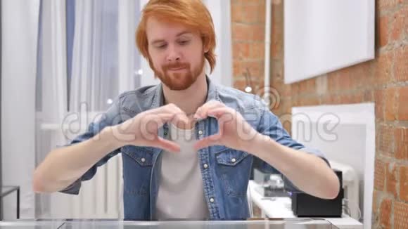 红发胡子男的心脏标志手手势视频的预览图