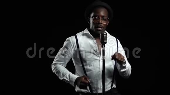 美国黑人男歌手对着麦克风唱歌跳舞黑色背景慢动作关门视频的预览图