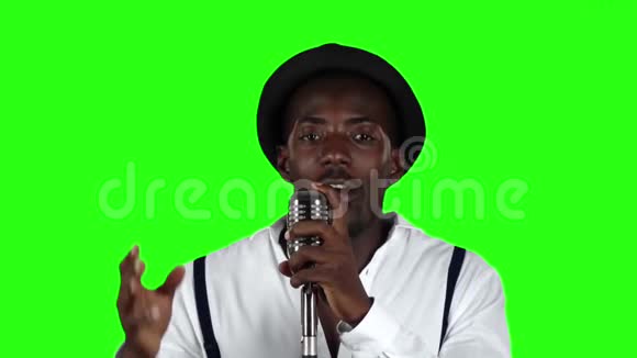 美国黑人男音乐家穿着衬衫和吊带在录音室唱歌绿色屏幕慢动作关闭视频的预览图
