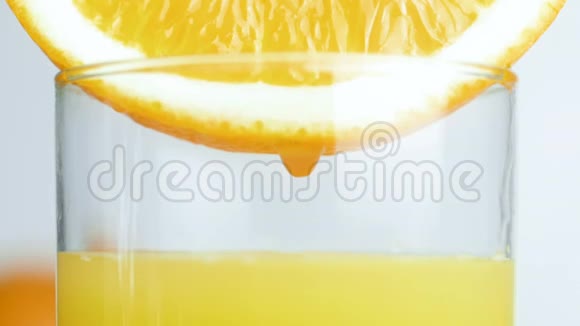 特写慢镜头的液滴慢慢落在橙汁杯中视频的预览图