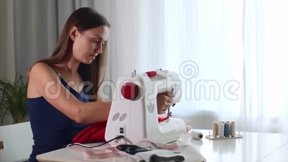 自营职业的年轻妇女裁缝在缝纫机上工作和缝纫布视频的预览图