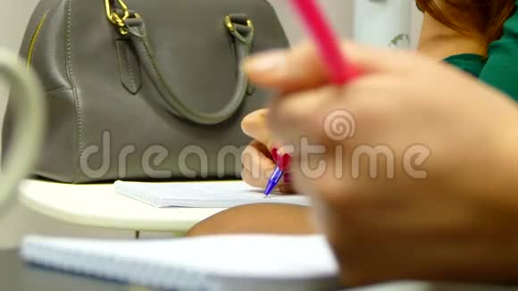 那个女孩在笔记本上写讲座视频的预览图