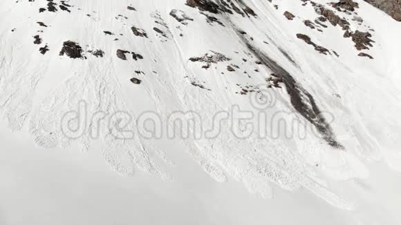 空中在雪坡上靠近雪崩的地方飞行春天显露出来视频的预览图