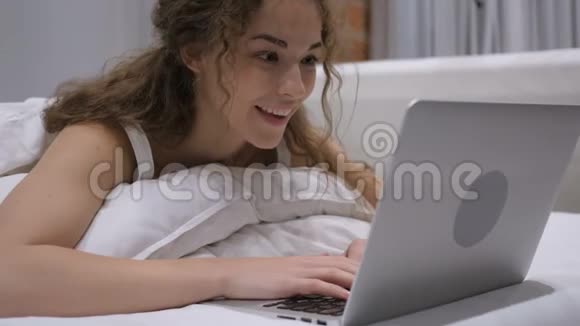 床上女性在线视频聊天耳机视频的预览图