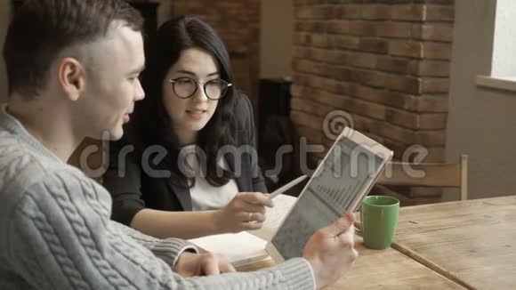 年轻人和看数字平板电脑的女人交谈视频的预览图