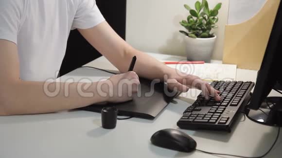 人在办公室里用钢笔平板做素描年轻工人手里拿着手写笔视频的预览图