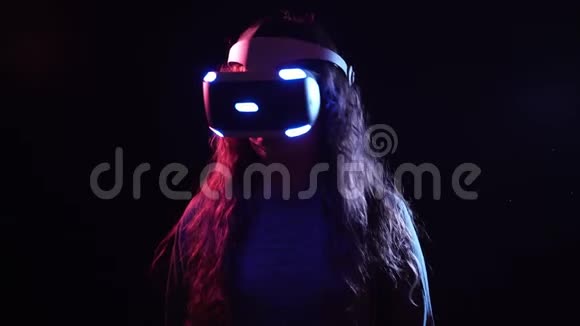 穿着VR耳机站在黑暗空间的年轻女子视频的预览图