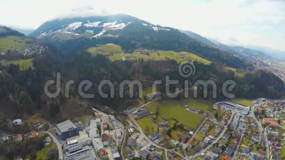 空中拍摄的大城市周围美丽的阿尔卑斯山绿色的山丘雪峰视频的预览图