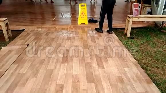 没有声音镜头值班清洁工清洁湿地板站在黄色警告湿标志而雨天视频的预览图