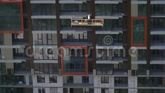 一个建筑工人戴着头盔在摩天大楼的平台中间视频的预览图