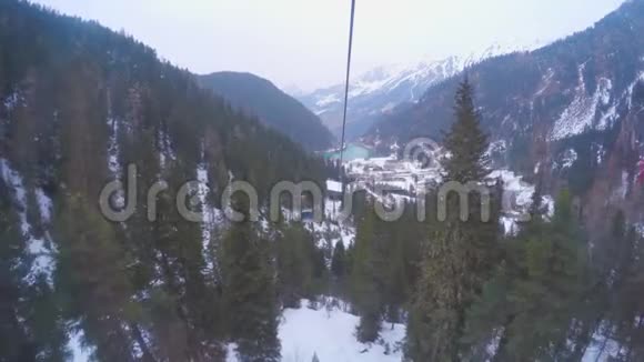 缆车在覆盖着白雪森林的高山上穿梭索道视频的预览图