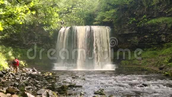 男子走在SgwdyrEira瀑布BreconBeacons国家公园视频的预览图