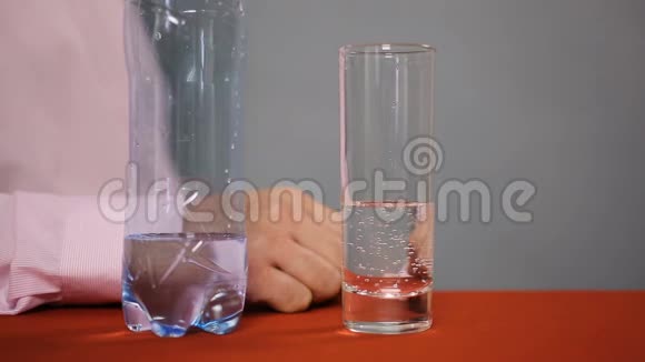 口渴的男人端着杯子喝着闪闪发光的矿泉水特写镜头视频的预览图
